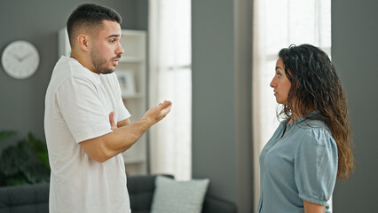 Obraz premium Man and woman couple standing together arguing at home