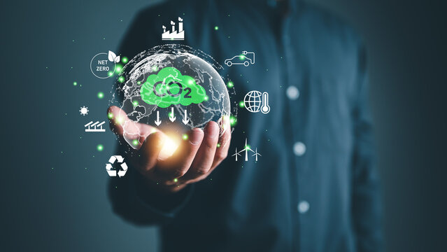 Hand holding virtual Global with CO2 reducing icon for concept of decrease carbon dioxide emission ,carbon footprint and carbon credit to limit global warming from climate change concept.