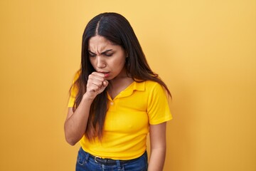 Young arab woman standing over yellow background feeling unwell and coughing as symptom for cold or bronchitis. health care concept.