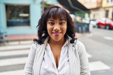 Young beautiful latin woman smiling confident standing at street