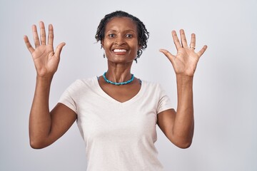 African woman with dreadlocks standing over white background showing and pointing up with fingers...