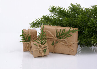Fototapeta na wymiar christmas composition with spruce twigs and eco packing gifts on white