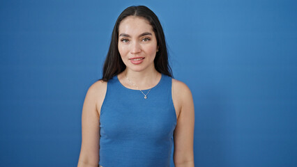 Young beautiful hispanic woman smiling confident standing over isolated blue background