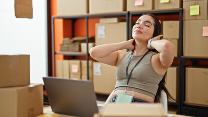 Young beautiful hispanic woman ecommerce business worker combing hair with hands at office