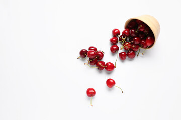 Bowl with sweet cherries on white background