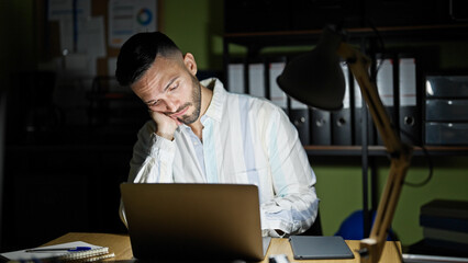 Fototapeta premium Young hispanic man business man working bored and tired at the office