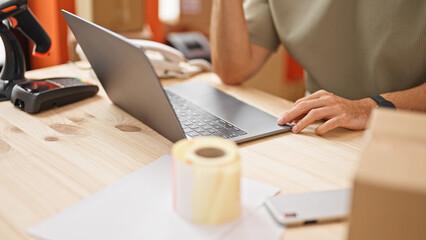 Young hispanic man ecommerce business worker using laptop at office