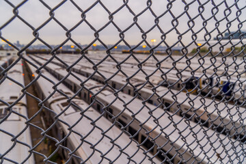 A train depot yard behind a fence in New York City at sunset 