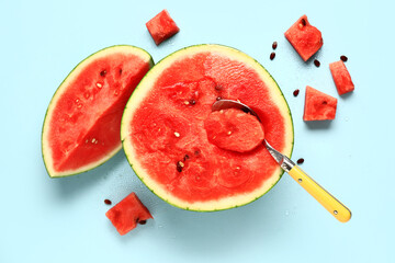 Half of fresh watermelon with pieces and seeds on blue background