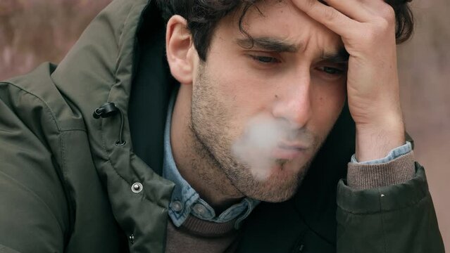 despair, problems -desperate young man on the verge of tears smokes a cigarette 