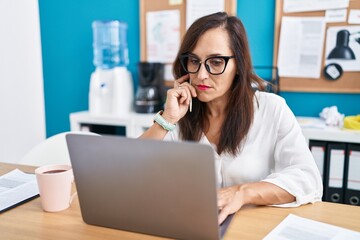 Obraz premium Young beautiful hispanic woman business worker using laptop with serious expression at office
