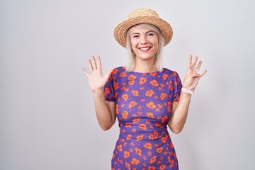 Young caucasian woman wearing flowers dress and summer hat showing and pointing up with fingers number nine while smiling confident and happy.