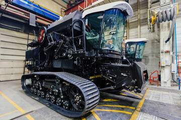 Agricultural machinery manufacturing. Assembly line of caterpillar tractors or harvesters