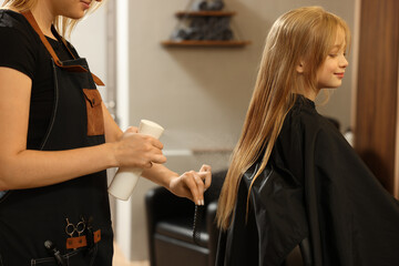 Professional hairdresser working with girl in beauty salon
