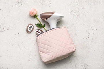 Bag with attachments for modern photoepilator and beautiful pink rose on grunge white background