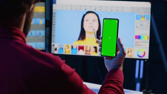 Photographer following online tutorial on mockup phone about using photo editing software to improve images quality. Photo editor learning from online guide on green screen smartphone
