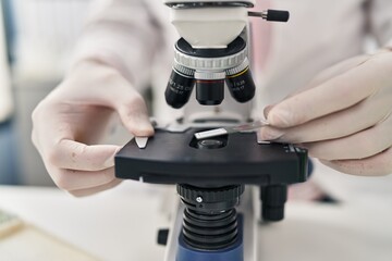 Middle age man scientist using microscope at laboratory