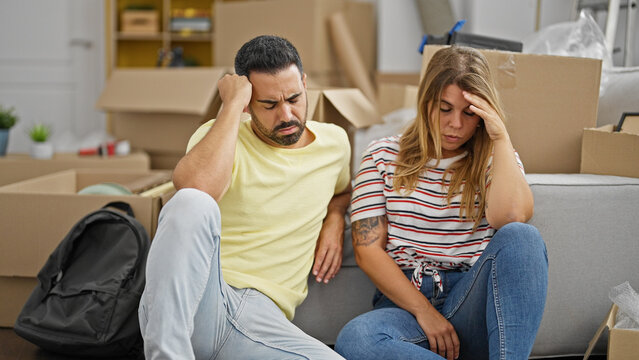 Man and woman couple sitting on floor stressed at new home