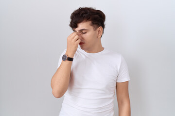 Young non binary man wearing casual white t shirt tired rubbing nose and eyes feeling fatigue and headache. stress and frustration concept.