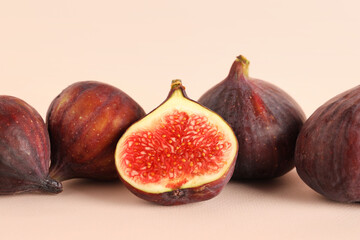 Fresh juicy cut figs on pale pink background