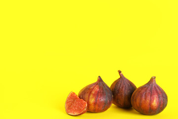 Fresh juicy cut figs on yellow background