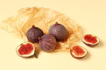 Baking paper with fresh ripe figs on yellow background