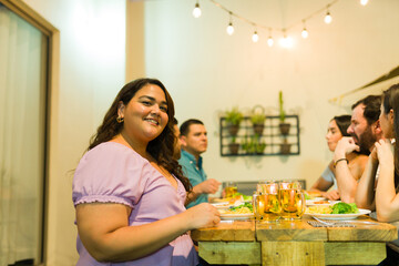 Beautiful plus size woman eating dinner with friends