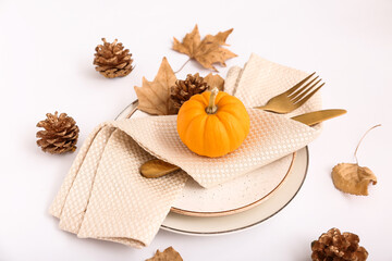 Obraz na płótnie Canvas Autumn table setting with pumpkin, leaves and cones on white background