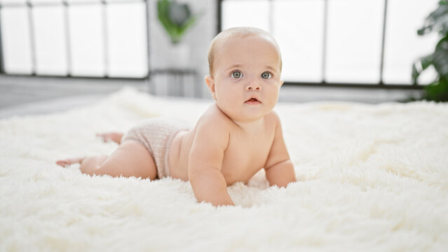 Adorable baby lying in comfort on the bed of a cozy bedroom inside a cute little apartment, embodying the pure lifestyle of a relaxed newborn awakening