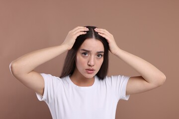 Fototapeta premium Emotional woman with healthy hair on beige background