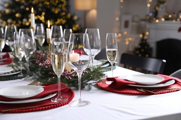 Christmas table setting with festive decor and dishware in room