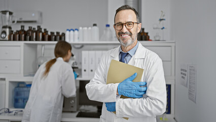 Obraz premium Two smiling scientists, partners in crime, nonchalantly standing with crossed arms in the laboratory, juggling documents of their latest mind-boggling medical research.