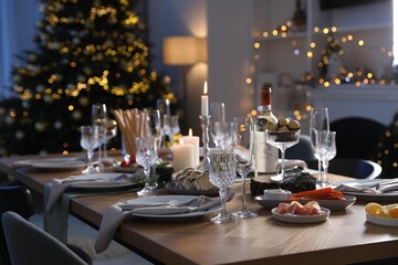 Christmas table setting with festive decor and dishware in room