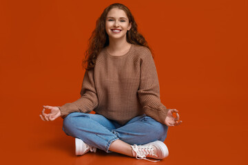 Portrait of relaxed young woman meditating on red background
