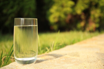 Pouring fresh water on stone surface outdoors, space for text