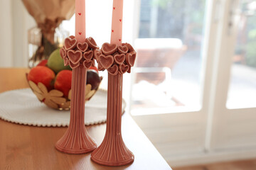 Bouquet of flowers, bowl with fresh fruits and candles on wooden table indoors, selective focus. Space for text