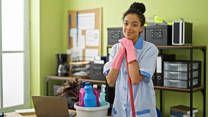 African american woman clean professional holding mop smiling at office