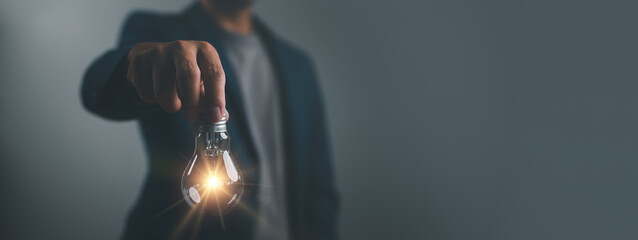 Idea concept creative thinking, Hand of man holding illuminated light bulb, idea, innovation and...