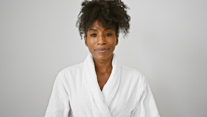 African american woman wearing bathrobe standing with serious face over isolated white background