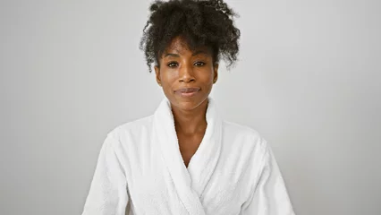 Foto op Canvas African american woman wearing bathrobe standing with serious face over isolated white background © Krakenimages.com