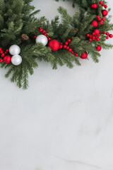 Fototapeta na wymiar Christmas wreath with red and white decorations and Christmas balls on white and gray background. Vertical image
