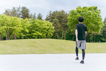 公園を歩く・ウォーキングする男性・スポーツマン・アスリート（全身）
