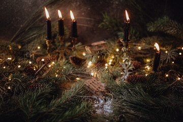 Christmas dark academia vintage winter wooden table with fir branches, pine cones, black candles...