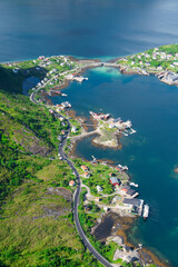 Amazing view from Reinebringen view point. Mountains and blue sea at Lofoten islands. Scenery of Reine fishing village. One of most popular hiking trails in North of Norway.