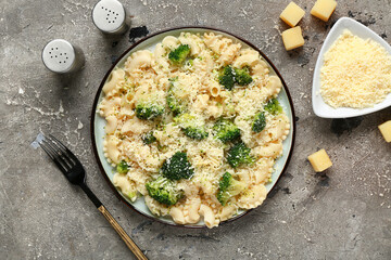 Plate of tasty pasta with broccoli on grey background