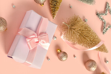 Gift box with Christmas decorations on pink background