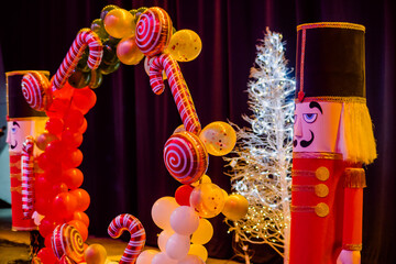 Naklejka premium Christmas decorations such as giant nutcracker dolls, balloons of different shapes such as candy, stars and classic balloons, in the background a Christmas tree.