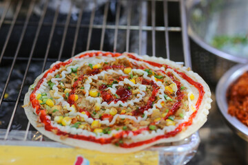 High angle view of grilled vietnamese pancake with eggs sausages and sauces in food festival