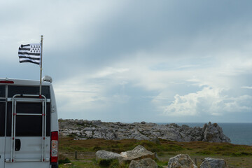 Drapeau breton sur un camping-car face à la mer en Bretagne-France - obrazy, fototapety, plakaty