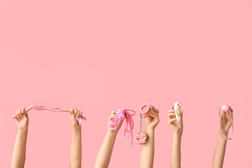 Female hands with different sex toys on pink background - obrazy, fototapety, plakaty
